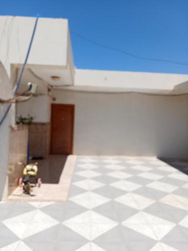 an empty room with a checkered floor and a toy at Cléopâtre épouse de Juba ll in Tefeschoun