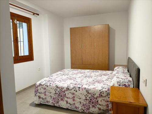 ein Schlafzimmer mit einem Bett und einem Holzschrank in der Unterkunft Apartamento Costacabana in Almería