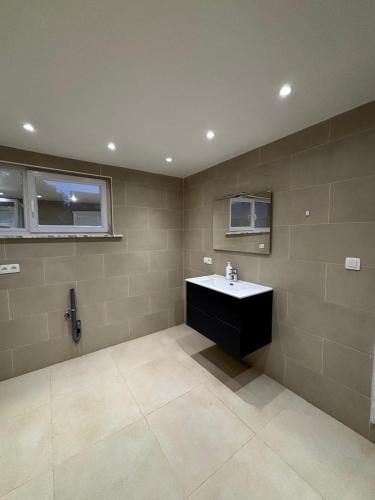 a bathroom with a sink and two windows at The Wandering House in Tremelo