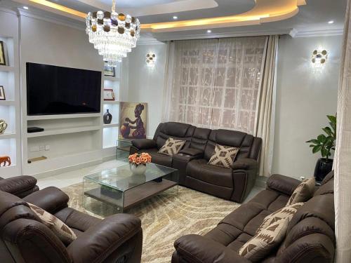 a living room with leather couches and a flat screen tv at Home in Kitengela kajiado in Kitengela 