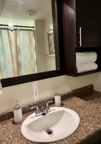 a bathroom with a sink and a mirror and towels at Apartamento en Ecovivienda Tegucigalpa in Tegucigalpa