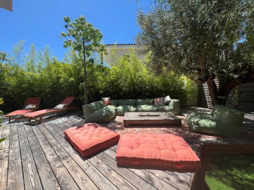 une terrasse avec des canapés, une table et des chaises dans l'établissement L'Oasis Secrète de la Corniche, à Sète