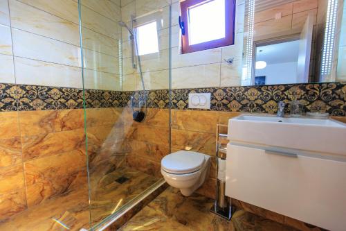 a bathroom with a toilet and a sink and a shower at Apartments Matkovic Lux in Sutomore