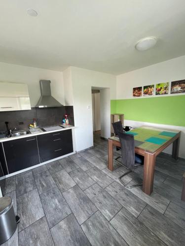 a kitchen with a wooden table in a room at Ferienwohnung Sonnendeck einladend und freundlich in Laupheim