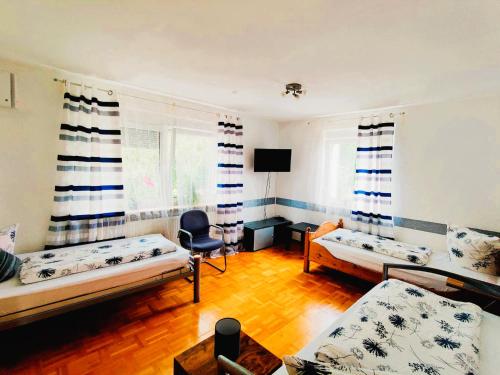 a living room with two beds and a chair at Ferienwohnung Sonnendeck einladend und freundlich in Laupheim