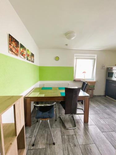 a kitchen with a wooden table and chairs at Ferienwohnung Sonnendeck einladend und freundlich in Laupheim