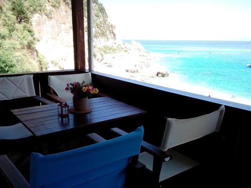 a table and chairs with a view of the ocean at Fetsis Apartments in Agios Nikitas