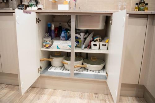 a kitchen cabinet filled with lots of food at ApArt Gallery Apartment 2, Stylish 3- Bed , Free Parking ,Sleeps 6 in Bedford