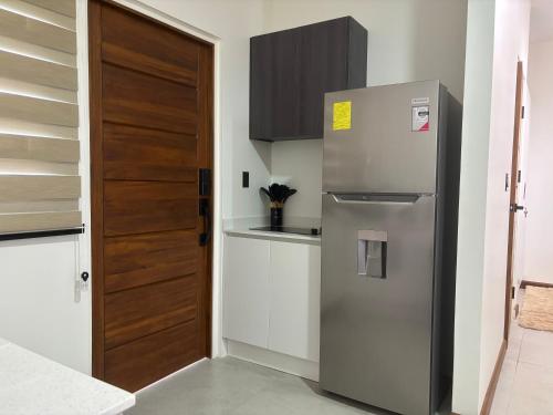 a kitchen with a refrigerator and a wooden door at Perfect stay apartments in Paramaribo