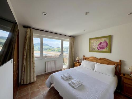 een slaapkamer met een groot bed en een groot raam bij La Ria - by Wehomes - Mogro River in Miengo