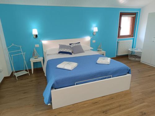 a bedroom with a bed with a blue wall at Zagare & Trabocchi - Dimora di mare in Rocca San Giovanni