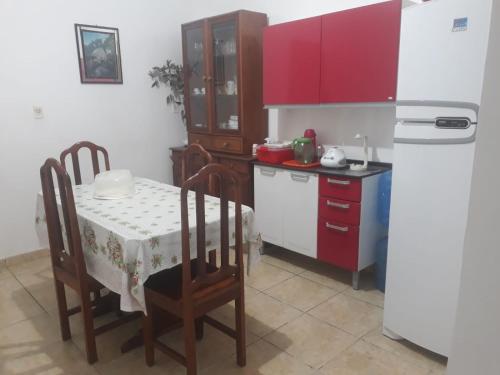 a kitchen with a table and a white refrigerator at Casa salinas prox orla in Salinópolis