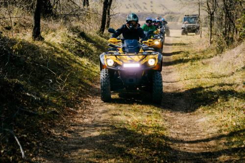 a group of people riding atvs on a dirt road at Gipsy Village Park Hotel in Asuretʼi