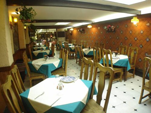 a restaurant with tables and chairs with blue and white table cloth at Hotel San Miguel in Puebla