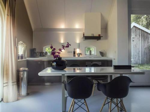 a kitchen with a counter with two chairs and a table at Design Lodge Twente in Buurse