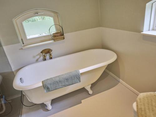 a white bath tub in a bathroom with a window at Design Lodge Twente in Buurse