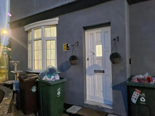 a house with two trash cans next to a door at New double room on gf in London