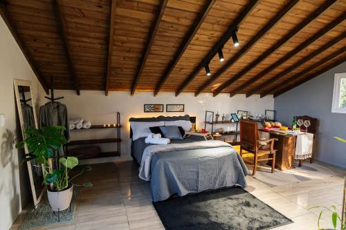 a bedroom with a bed and a desk and a table at Loft no Morro da Borússia in Osório