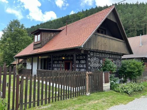 een zwart-wit huis met een houten hek bij Čičmanský ľudový dom in Čičmany