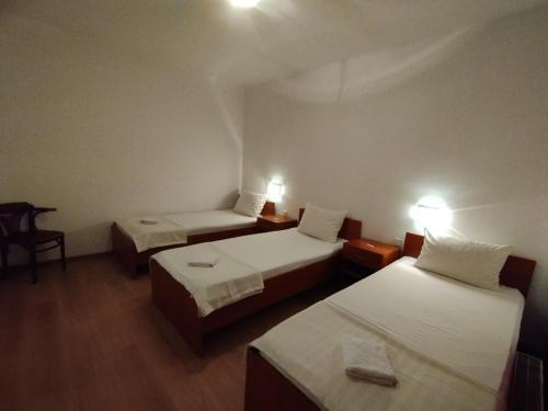 a hotel room with two beds and a desk at Motel Bella Italia in Sarajevo