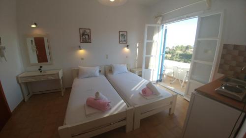 a bedroom with two beds with dolls on them at Oasis Studios Logaras in Logaras