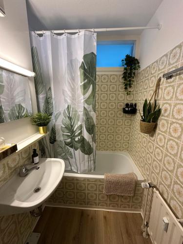 ein Badezimmer mit Waschbecken, Badewanne und Dusche in der Unterkunft Schmuckkästle in Sasbachwalden