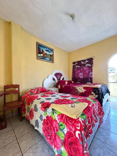 a bedroom with a bed with a colorful comforter at Hospedaje El Paraíso in San Pedro La Laguna
