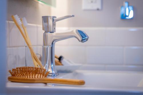 a sink with a toothbrush holder and a faucet at Marina Beach Motel in Santa Barbara