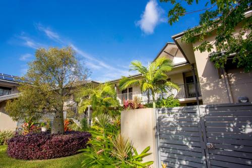 a house with a fence and trees in front of it at BIG4 Gold Coast Holiday Park in Gold Coast