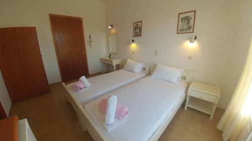 a bedroom with a white bed with towels on it at Oasis Studios Logaras in Logaras