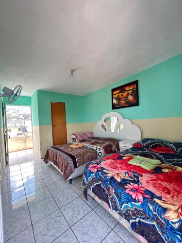 two beds in a room with blue walls at Hospedaje El Paraíso in San Pedro La Laguna