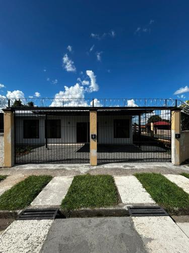 a building with a fence on the side of it at Caribe Loft in Guápiles