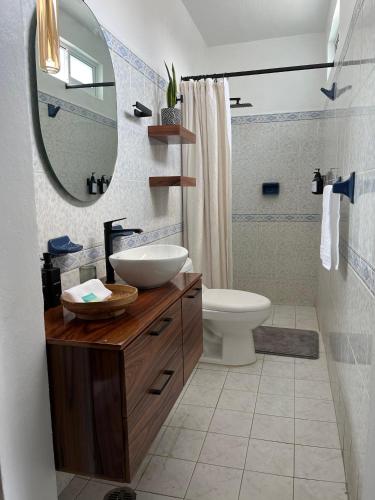 a bathroom with a sink and a toilet and a mirror at Casa de Alicia - Habitación Xaguar in Oaxaca City