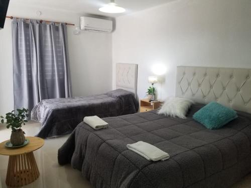 1 dormitorio con 2 camas y toallas. en Departamentos Aimogasta Vientos, en Arauco