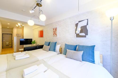 a living room with a white couch and blue pillows at 長者丸ビル 10 mins from Shibuya in Tokyo