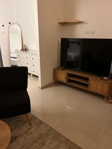 a living room with a flat screen tv on a entertainment center at יחידת אירוח כפרית in Gid‘ona