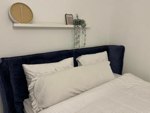 a bed with two pillows and a clock on a wall at יחידת אירוח כפרית in Gid‘ona