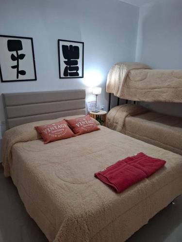 a bed with two pillows on it in a room at Departamentos Aimogasta Vientos in Arauco