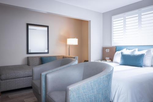 a hotel room with a bed and a couch and a chair at Marina Beach Motel in Santa Barbara
