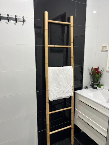 a bathroom with a wooden towel rack next to a sink at יחידת אירוח כפרית in Gid‘ona