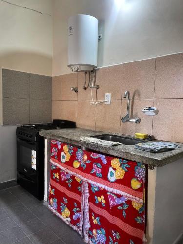 a kitchen with a sink and a stove at Casa familiar cómoda in Santiago del Estero
