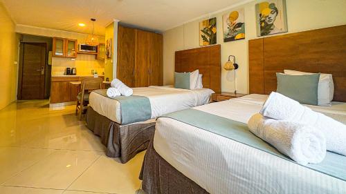a hotel room with two beds and a kitchen at Majestic City Suites & Beach Hotel in Willemstad
