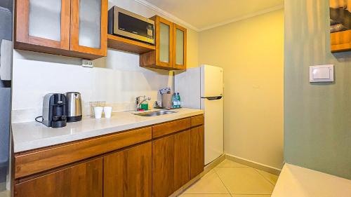 a small kitchen with a sink and a refrigerator at Majestic City Suites & Beach Hotel in Willemstad