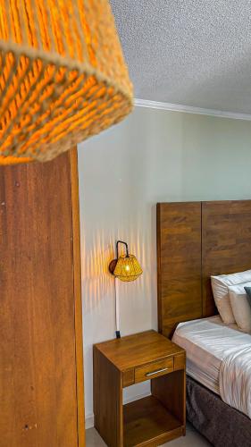 a bedroom with a bed and a table with a lamp at Majestic City Suites & Beach Hotel in Willemstad