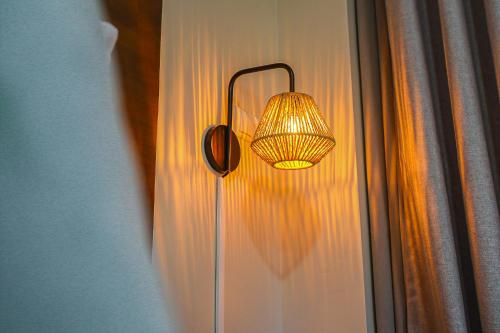 a lamp hanging on a wall with a window at Majestic City Suites & Beach Hotel in Willemstad