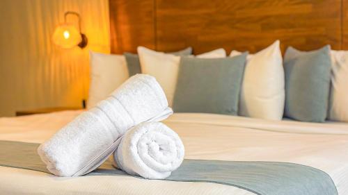 a rolled up towel on a bed in a hotel room at Majestic City Suites & Beach Hotel in Willemstad