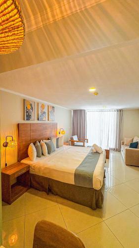 a bedroom with a large bed and a couch at Majestic City Suites & Beach Hotel in Willemstad
