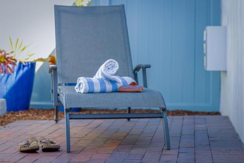 a blue chair with a towel and a pair of shoes at Marina Beach Motel in Santa Barbara