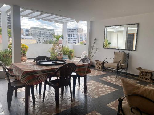 a dining room with a table and chairs and a mirror at Touty in Dakan