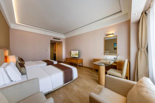 a hotel room with a large bed and a desk at Weihai Haiyue Jianguo Hotel in Weihai